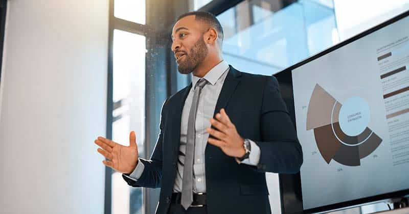 Businessman doing a presentation with chart on a large monitor