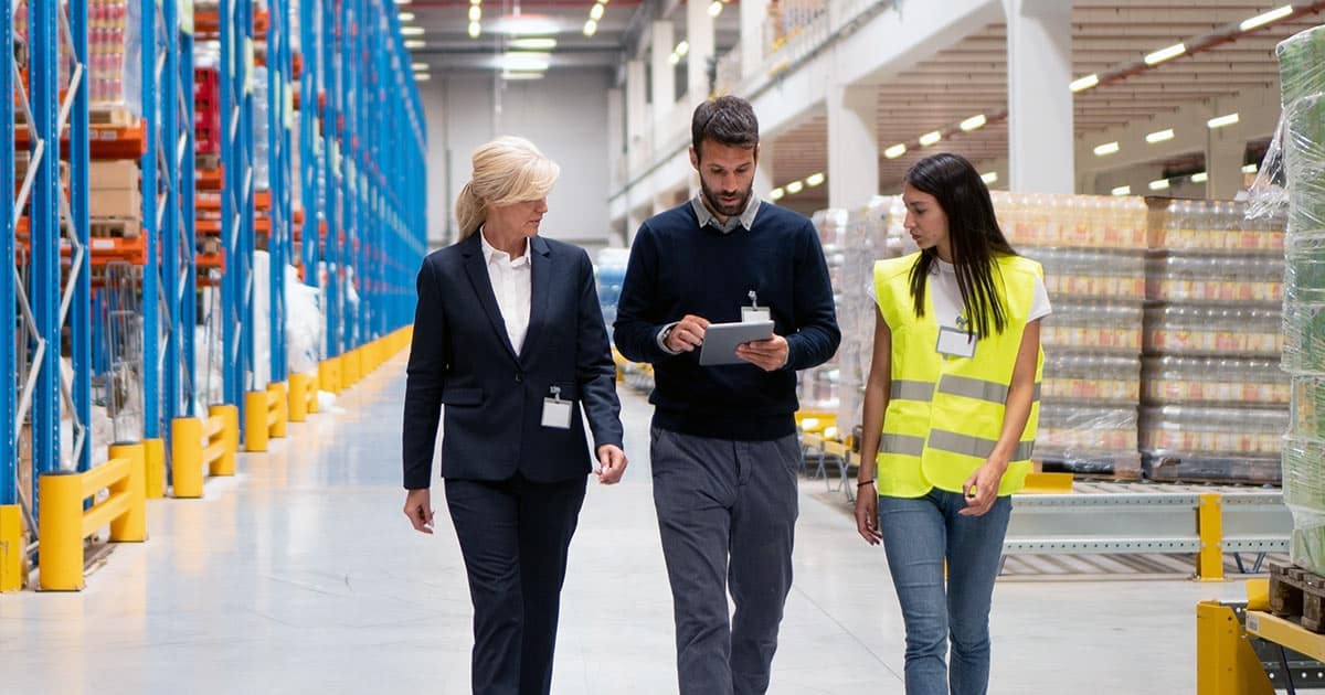 Managers stroll through a factory warehouse