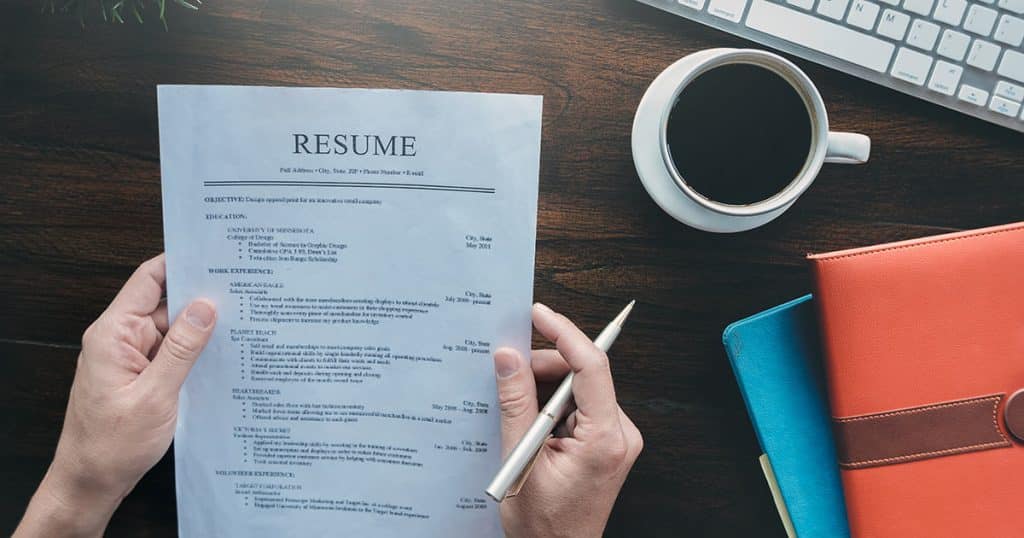Professional reading a resume at a desk